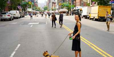 woman with dog at the middle of the street