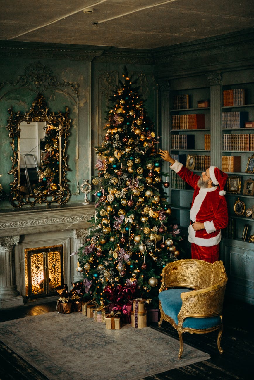 man standing beside christmas tree