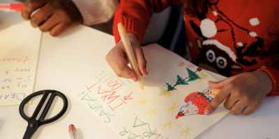 a person in red sweater making a christmas letter