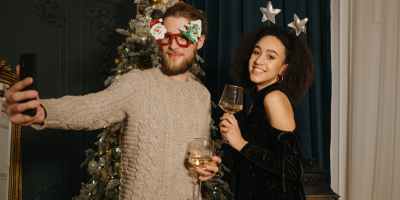 couple drinking champagne near christmas tree