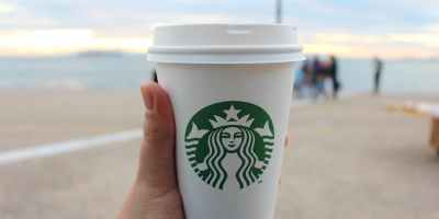 person holding star buck plastic cup