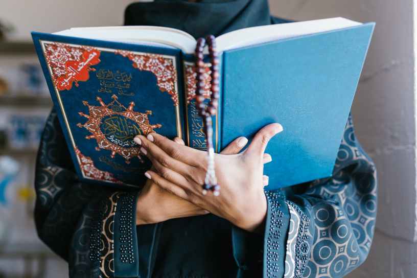 person holding blue holy book