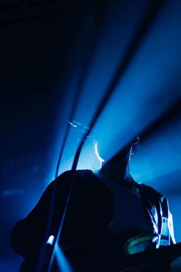 unrecognizable musician singing and playing guitar during concert