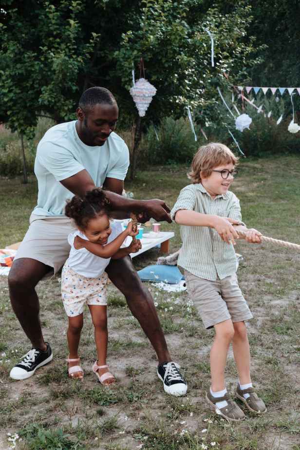 dad and kids playing tug of war