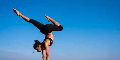 woman with arms outstretched against blue sky
