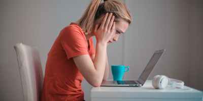 young troubled woman using laptop at home